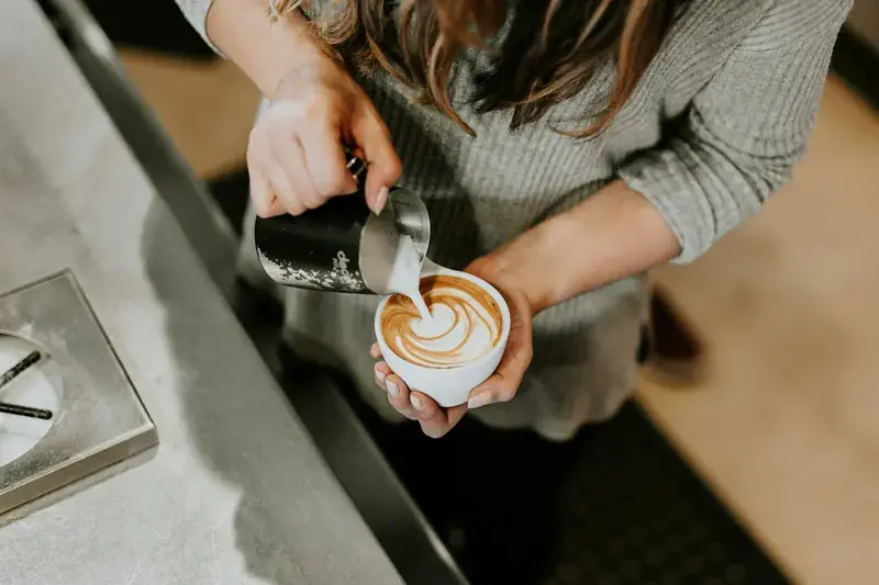 A barista handing a cup across the counter