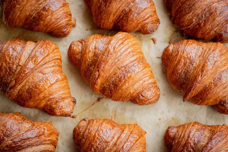 Freshly baked croissants cooling on parchment